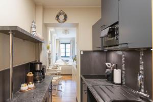 a kitchen with stainless steel appliances and a living room at Ferienwohnung Baltic in Barth
