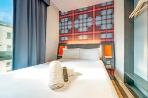 a bedroom with a bed with a remote control on it at easyHotel Dublin in Dublin +40 photos
