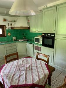 a kitchen with a table and a kitchen with green cabinets at Casa di Eli e Matte in Le Serucce