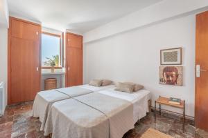 a bedroom with a white bed and a window at Bennassar 3 in Felanitx