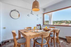 a dining room with a wooden table and chairs at Bennassar 3 in Felanitx +17 photos