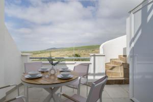 a table and chairs on the balcony of a house at Moderno Apartamento Atlanterra in Zahara de los Atunes