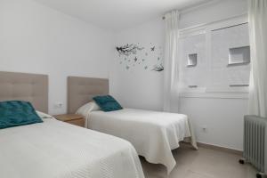 a bedroom with two beds and a window at Moderno Apartamento Atlanterra in Zahara de los Atunes +23 photos