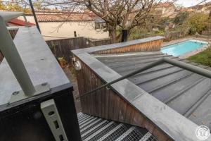 a wooden ramp leading to a swimming pool at Chambre d'hôtes oyasumi in Muret