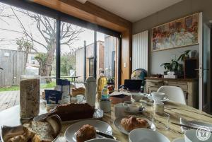 a table with plates of food on top of it at Chambre d'hôtes oyasumi in Muret