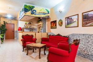a waiting room with red chairs and a table at Hotel Da Concetta a Jerzu in Jerzu
