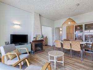 a living room with a couch and a table with chairs at Villa 32 - Villa With Garden in Esposende