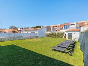 a lawn with two lounge chairs on top of it at Villa 32 - Villa With Garden in Esposende