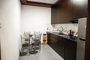 a kitchen with a counter with stools in it at Villa R in Negombo