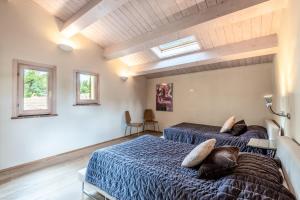two beds in a room with two windows at Villa Aquila in Trequanda +37 photos