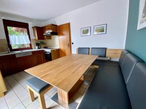 a kitchen with a wooden table and chairs at Haus Peeneblick in Freest