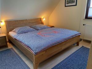 a bedroom with a bed with a blue and white comforter at Haus Peeneblick in Freest