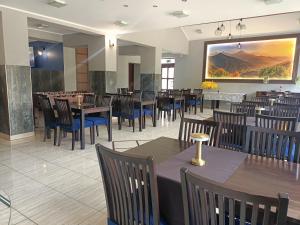 a restaurant with tables and chairs and a large painting on the wall at Monali in Karpacz