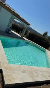 a swimming pool in front of a house at Oasi del relax in Budoni