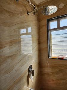 a bathroom with a shower with a window at Twilight Stays ll 2 Bed Villa ll Swimming Pool ll AC ll BBQ in Lonavala
