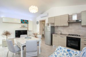 a kitchen and dining room with a table and chairs at Oasi del relax in Budoni