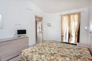 a bedroom with a bed and a tv and a window at Oasi del relax in Budoni +25 photos