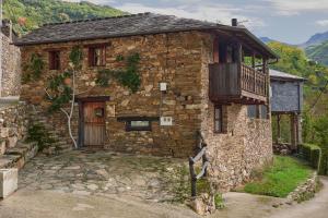 an old stone house with a balcony on the side at Casa Rural Cornatel in Villavieja
