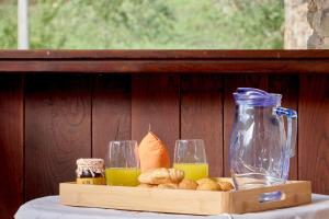 a wooden tray with food and glasses of orange juice at Casa Rural Cornatel in Villavieja +21 photos