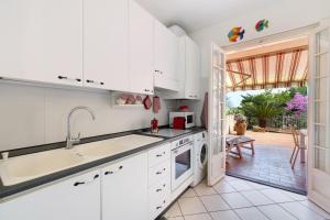 a white kitchen with a sink and a dishwasher at Casa Ghibli in Loano