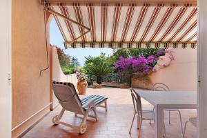 a patio with a table and chairs and flowers at Casa Ghibli in Loano