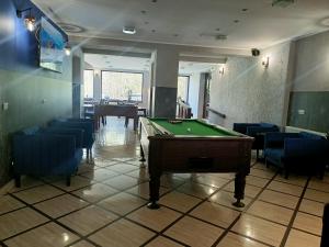 a room with a pool table and some blue chairs at Monali in Karpacz