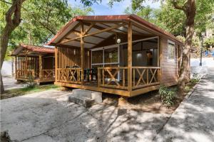 a small cabin with a porch with a large window at Kampaoh Conil in Conil de la Frontera