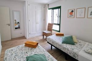a room with two beds and a chair in it at Canaima 223 - Puerto Rico in Puerto Rico de Gran Canaria +13 photos