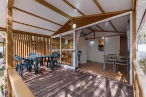 a screened in porch with a table and chairs at Kampaoh Conil in Conil de la Frontera