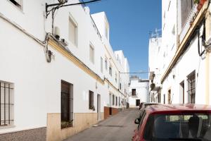 a red car parked on a street between two buildings at Atico Juani in Conil de la Frontera