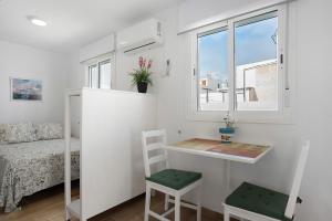 a small room with a desk and a bed and a window at Atico Juani in Conil de la Frontera
