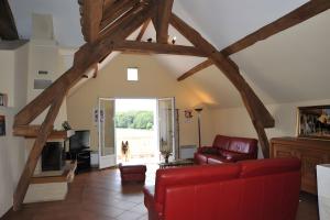 a living room with a red couch and a dog at Haras de la fontaine Datcha in Poligny