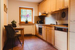 a kitchen with wooden cabinets and a table and a window at Apartment Andreas - Gallhof in Vollan