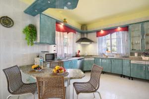 a kitchen with blue cabinets and a table with fruit on it at Eveas - Villa with Pool in Tenerife in Candelaria