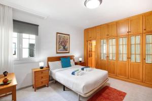 a bedroom with a bed and wooden cabinets at Eveas - Villa with Pool in Tenerife in Candelaria +21 photos