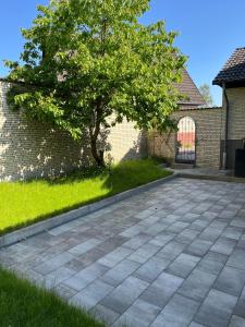 a tree in a yard next to a brick wall at Gemütliche Unterkunft mit Terrasse in Quickborn