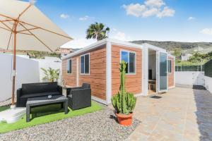 a tiny house with a couch and an umbrella at Casa Hoya de Carta in Candelaria