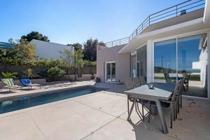 a patio with a table and chairs next to a pool at Blava in Begur