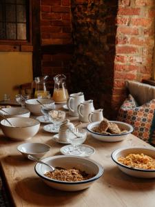 a wooden table topped with bowls and plates of food at The Queen's Head in Broad Chalke