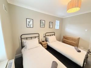two beds in a room with white walls at The Hideout in Southampton