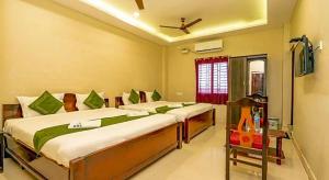 a bedroom with two beds and a television in it at Hotel Ramleela in Rāmeswaram
