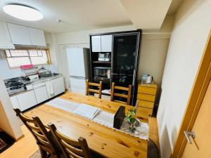 a kitchen with a wooden table and a dining room at HOTEL k&m in Tokyo