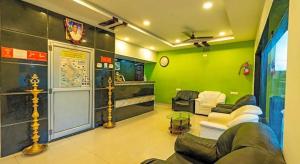 a living room with a couch and a green wall at Hotel Ramleela in Rāmeswaram