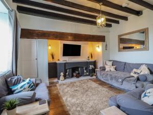 a living room with a couch and a fireplace at Glanrafon in Llwyngwril