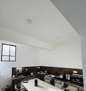 a kitchen with white walls and a table in it at Mirador Cottage in Bandarawela