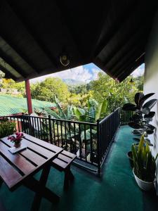 a porch with a picnic table on a balcony at Mirador Cottage in Bandarawela