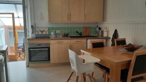 a kitchen with a wooden table and a dining room at 4 étoiles spacieux Gîte centre-ville, terrasse ensoleillée, parking et Wi-Fi in Magnac-Laval