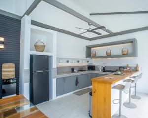 a kitchen with blue cabinets and a wooden counter at Villa Kalachuchi Bohol in Panglao Island