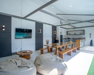 a dining room with a table and a couch at Villa Kalachuchi Bohol in Panglao Island