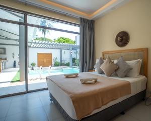 a bedroom with a large bed and a large window at Villa Kalachuchi Bohol in Panglao Island +54 photos